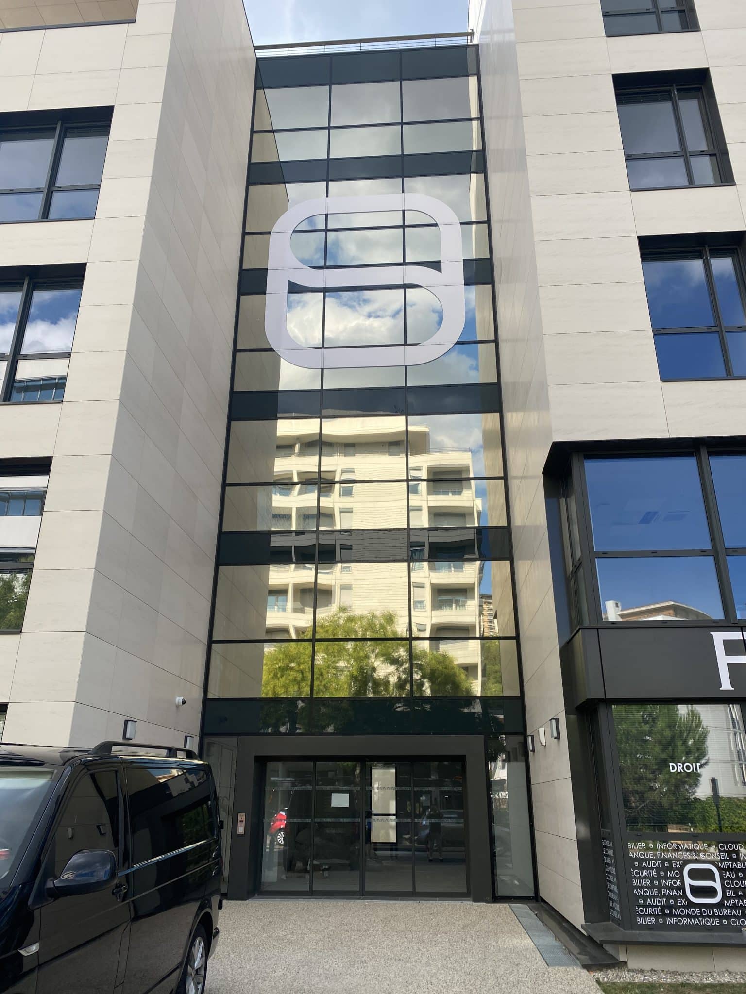 Façade vitrée d'immeuble de bureaux ornée d'un grand logo en film adhésif