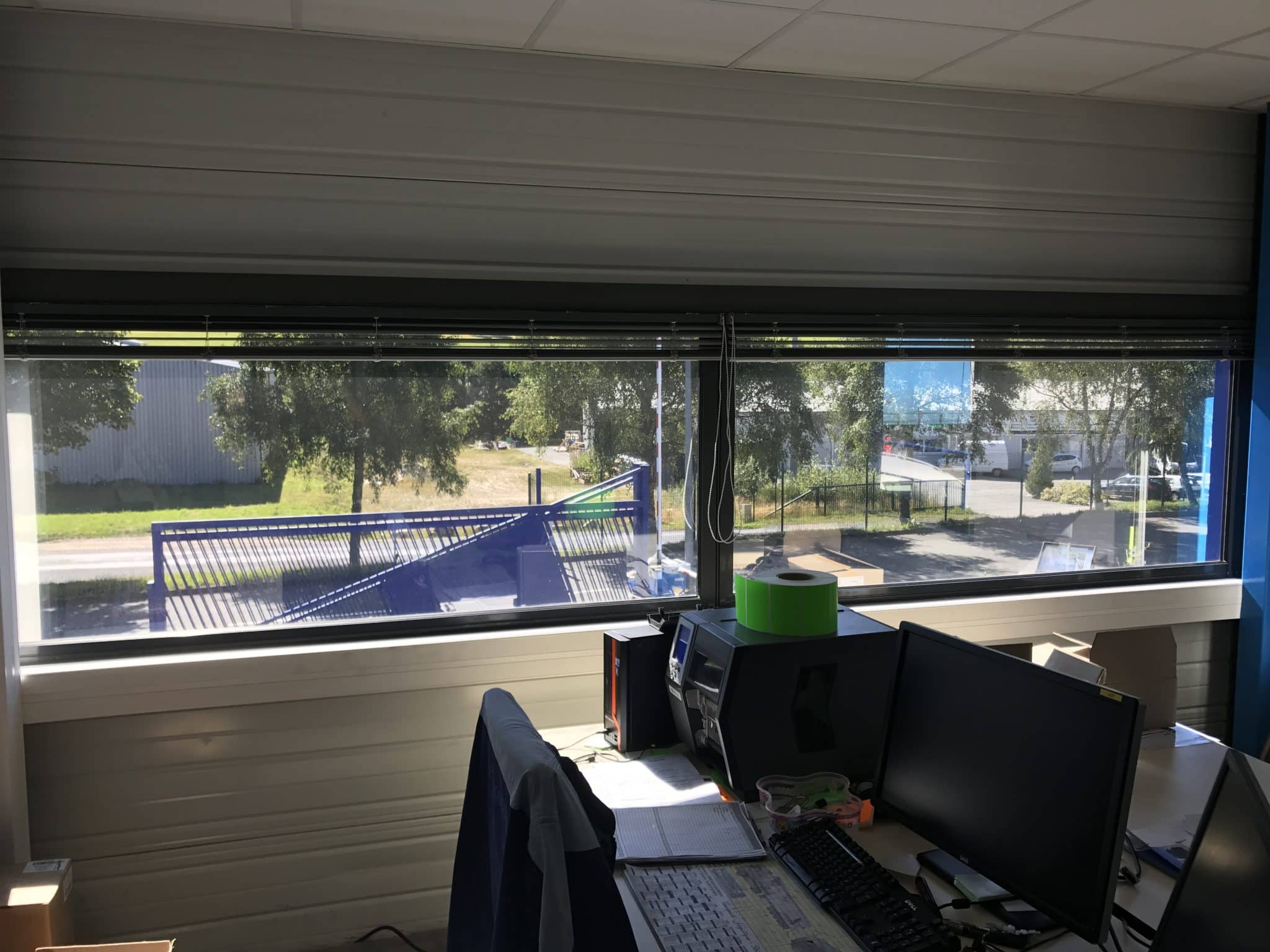 Poste de travail face à une grande baie vitrée exposée au soleil