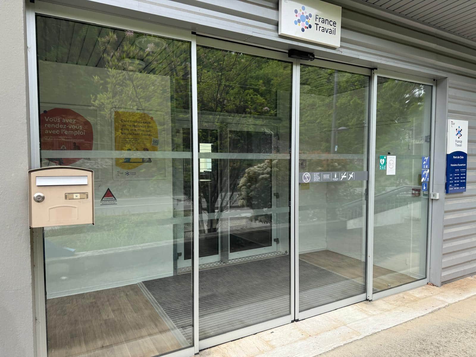 Entrée vitrée d'un établissement recevant du public avec portes et parois en verre