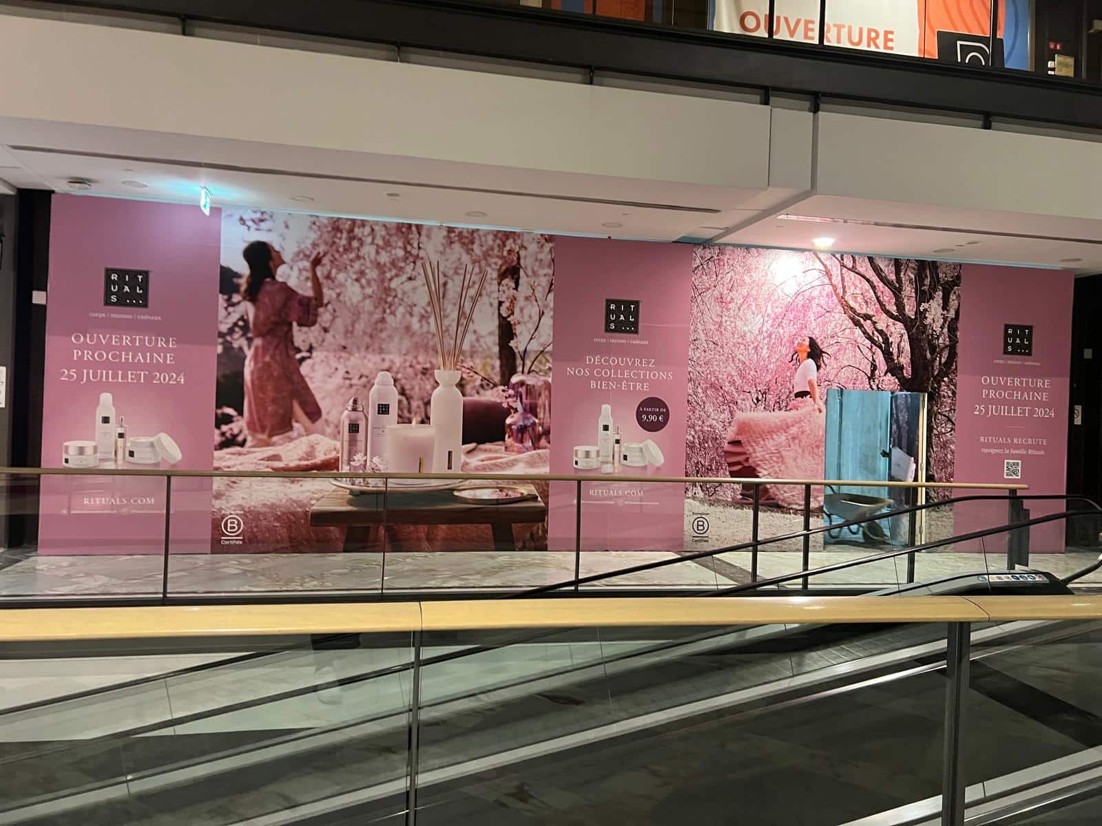 Vitrine de boutique en galerie commerciale entièrement habillée d'une vitrophanie imprimée annonçant une ouverture